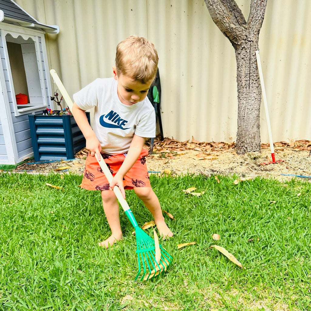 Child Using Ryset Kids Long Handle Lawn Rake.