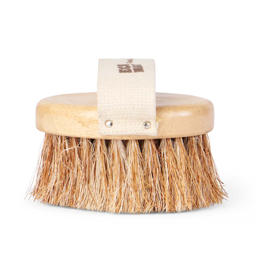 Round spa body brush with compostable wooden base with sisal and coconut fibres.