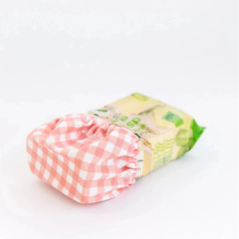 Small Food Cover in Red Gingham Covering Block of Cheese.