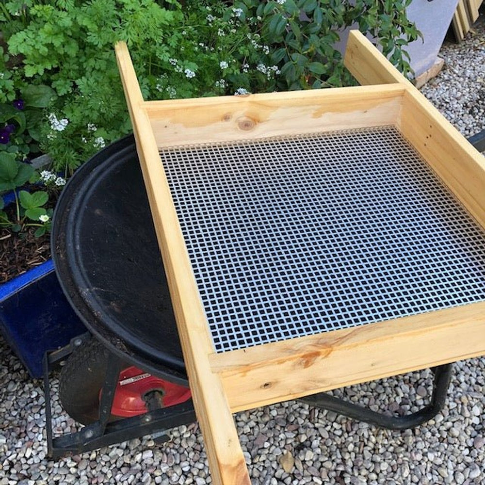 Compost Sieve, Lying Across a Wheelbarrow